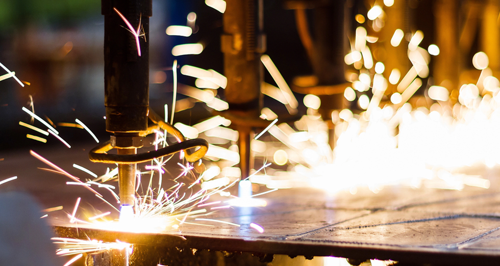 Robotic welding equipment performing precision metal fabrication in an aerospace manufacturing facility, generating sparks during automated production.