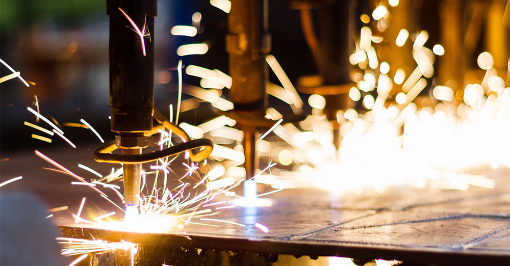 Robotic welding equipment performing precision metal fabrication in an aerospace manufacturing facility, generating sparks during automated production.