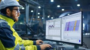 Factory engineer monitoring real-time production and manufacturing data on digital dashboards in a smart factory environment