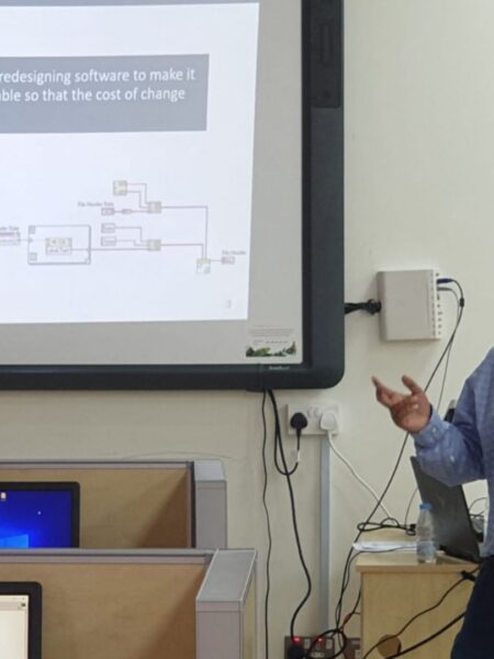 Engineer presenting a software refactoring concept in a university classroom