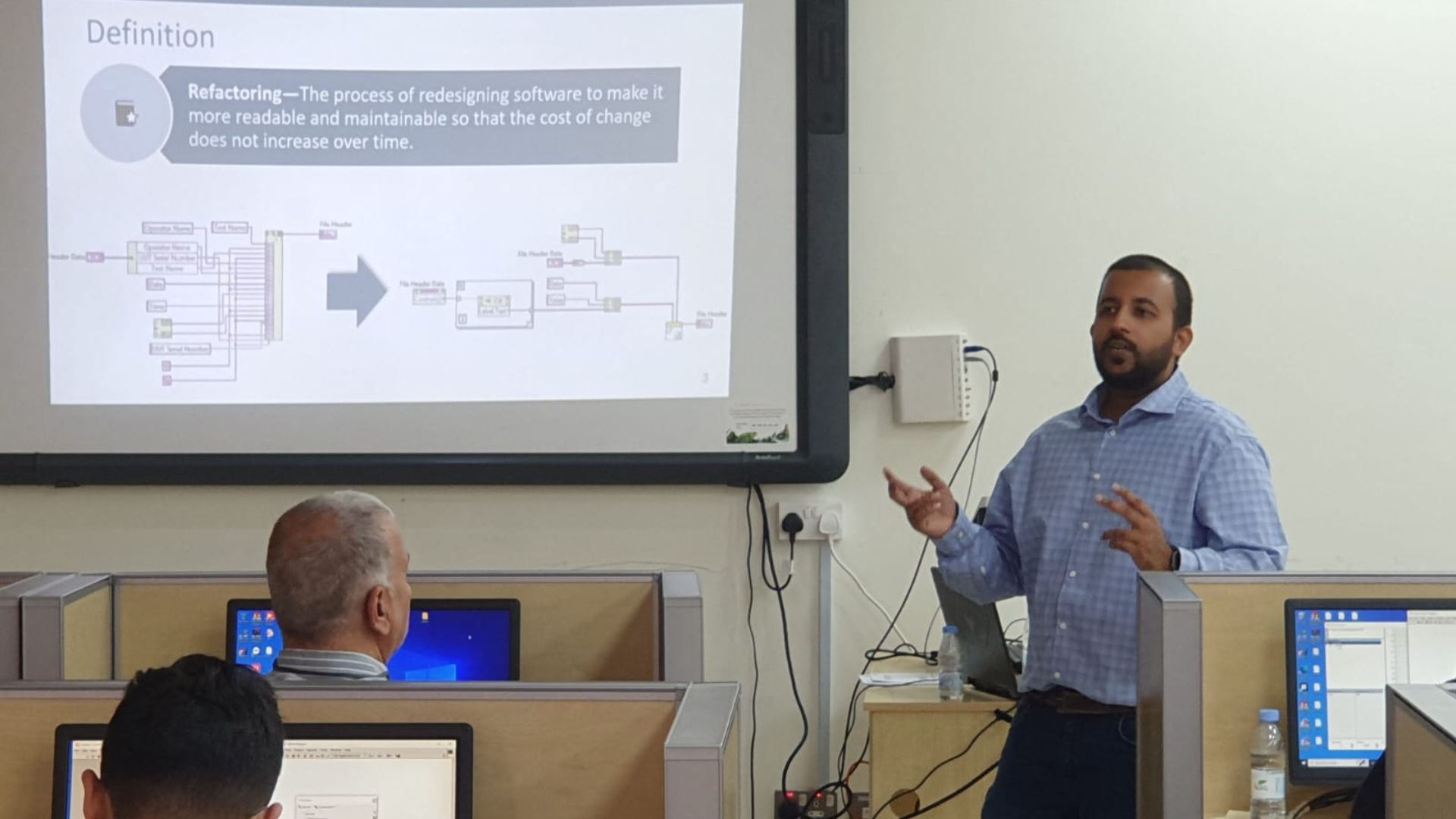 Engineer presenting a software refactoring concept in a university classroom